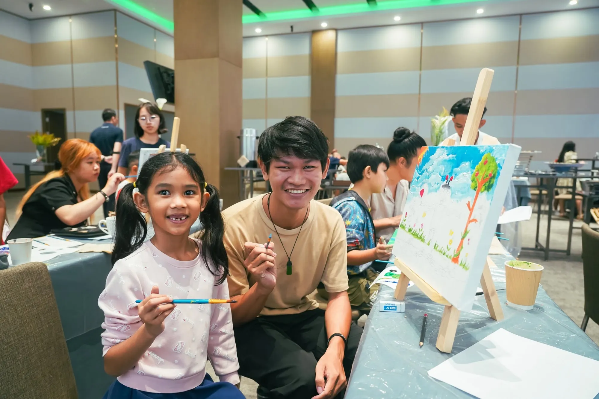 Child and volunteer painting at an easel